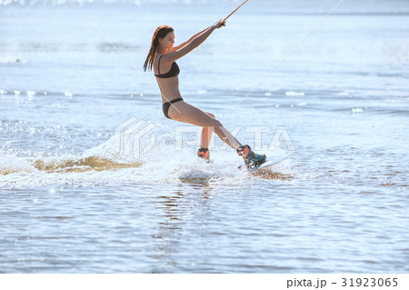 Woman in a bathing suit goes for wakeboarding. 31923065