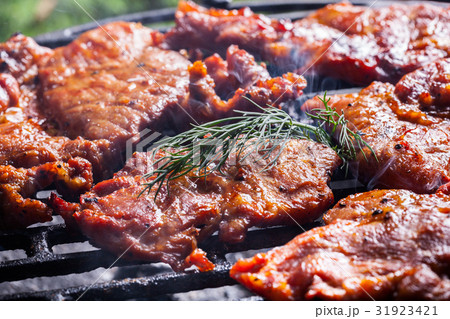 Grilling pork steaks on barbecue grill 31923421