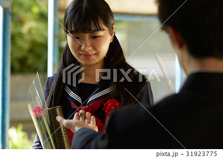 卒業式 第二ボタンをもらう女の子の写真素材