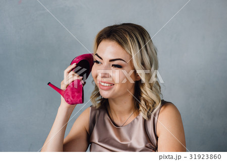 Beautiful girl holds a pink shoe in her hand 31923860