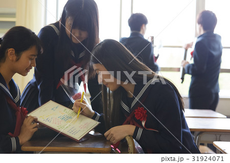 色紙に寄せ書きをする卒業生 31924071