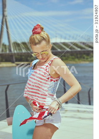 Beautiful young blonde woman with his longboard in the city in s 31924907