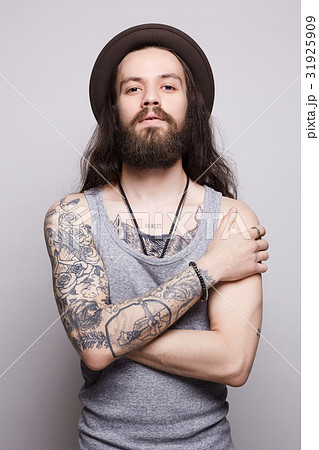 tattoed handsome bearded man in hat tattoed handsome bearded man in hat 31925909