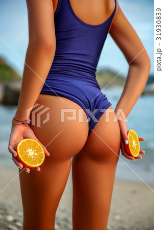 back of a beautiful woman in Swimsuit with Orange back of a beautiful woman in Swimsuit with Orange 31930839