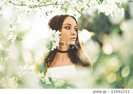 Beautiful young woman surrounded by flowers of apple-tree 31932231