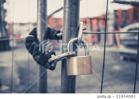 chain and padlock on gate at construction site chain and padlock on gate at construction site 31934091