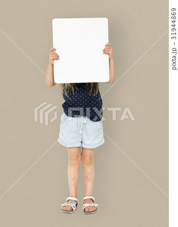 Little girl smiling and holding blank placard cover her face Little girl smiling and holding blank placard cover her face 31944869