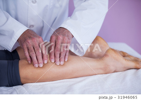 Physiotherapist giving leg massage to a woman Physiotherapist giving leg massage to a woman 31946065