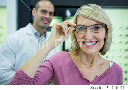 Female customer wearing spectacles in optical store Female customer wearing spectacles in optical store 31946101