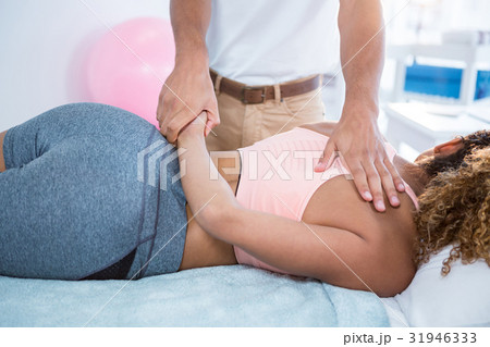 Physiotherapist giving hand massage to a woman 31946333