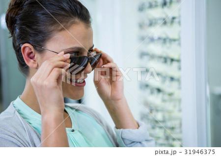 Smiling female customer trying spectacles 31946375