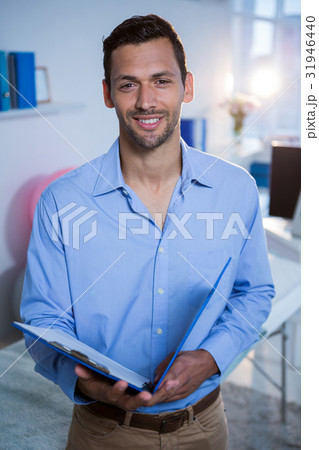 Smiling physiotherapist holding clipboard in clinic 31946440