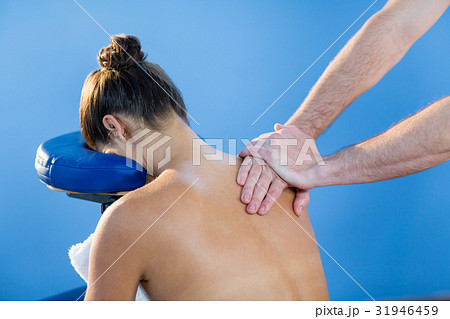 Physiotherapist giving shoulder massage to a female patient 31946459