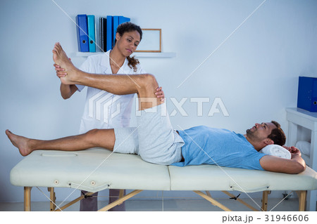 Physiotherapist giving leg massage to a patient Physiotherapist giving leg massage to a patient 31946606