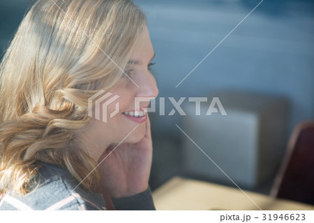 Smiling woman sitting in cafeteria 31946623