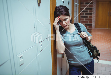 Stressed mature student standing in locker room 31946629