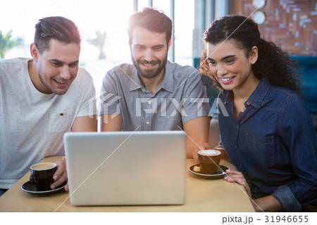Friends using a laptop in the coffee shop 31946655