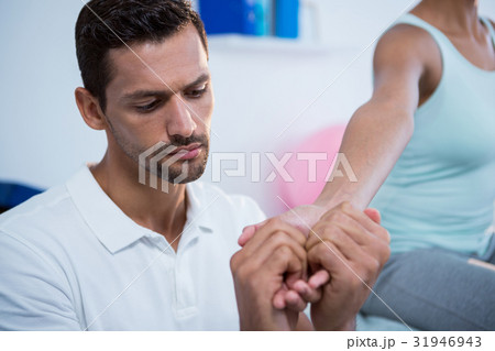 Physiotherapist massaging hand of a female patient Physiotherapist massaging hand of a female patient 31946943