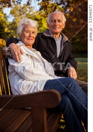 Senior couple embracing on a bench Senior couple embracing on a bench 31946971