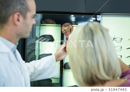 Female customer wearing spectacles and checking in mirror 31947493