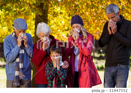 Sick family blowing their noses at park 31947552