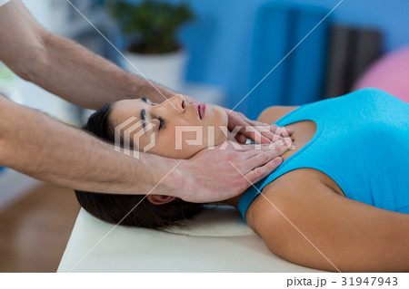 Male physiotherapist giving head massage to female patient Male physiotherapist giving head massage to female patient 31947943