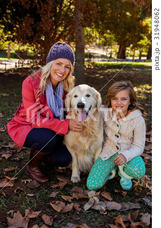 Mother and daughter caressing their dog 31948062