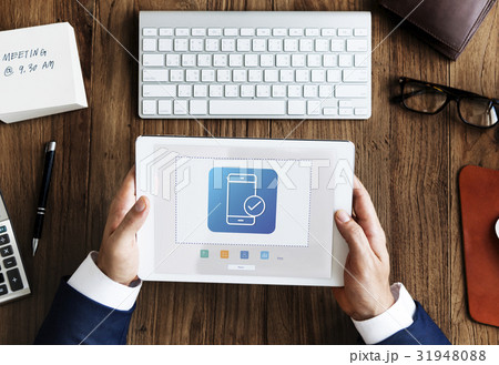 Hands working on digital device network graphic overlay 31948088