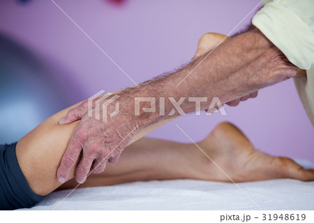 Physiotherapist giving leg massage to a woman Physiotherapist giving leg massage to a woman 31948619