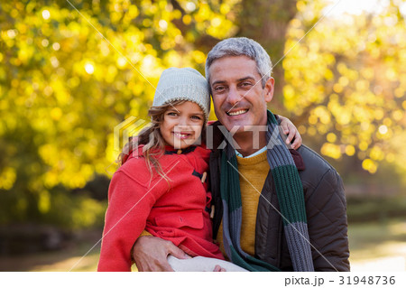 Father carrying daughter at park 31948736