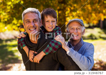 Man piggybacking son while with father at park 31948767