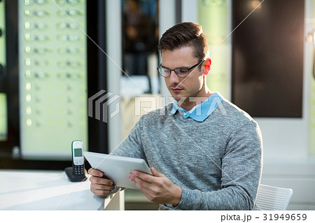 Customer using digital tablet in optical store 31949659