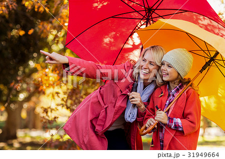 Happy woman pointing while standing by daughter Happy woman pointing while standing by daughter 31949664