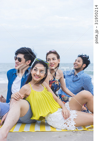 four happy people are sitting and looking at something together 31950214