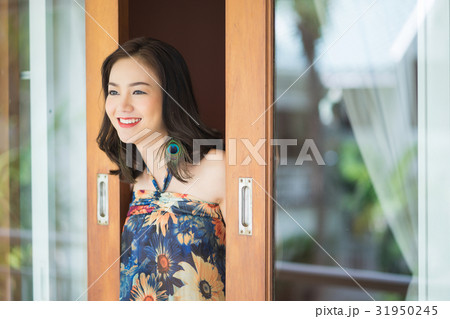 A young girl is smiling and opening the window 31950245