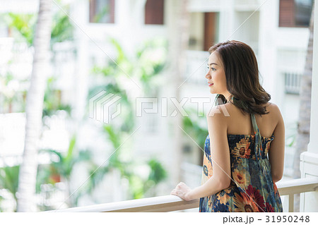 Beautiful lady is standing at balcony and looking something 31950248