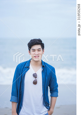 A photo of a happy man standing in seaside 31950268