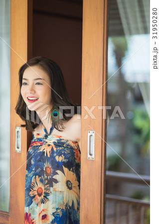 A smiling woman is standing at open door A smiling woman is standing at open door 31950280