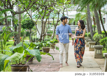 A couple is strolling happily in a resort. 31950309
