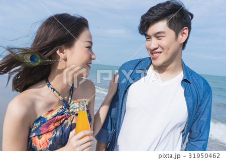 a couple is looking at each other and smiling on the beach. a couple is looking at each other and smiling on the beach. 31950462