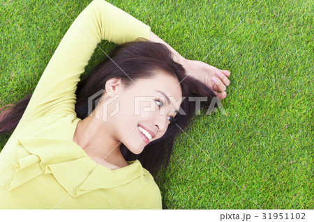 young woman lying and looking side in a meadow 31951102