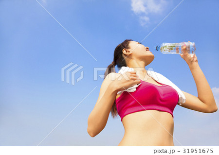 sporty woman drinking water  bottle after jogging 31951675