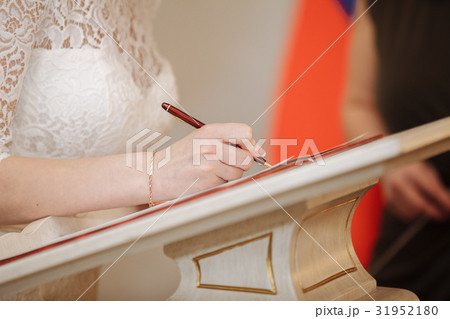 bride puts his signature pen in the registration bride puts his signature pen in the registration 31952180