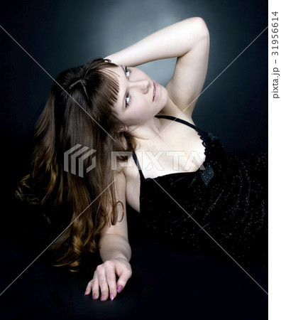 brunette girl posing in studio on dark background brunette girl posing in studio on dark background 31956614