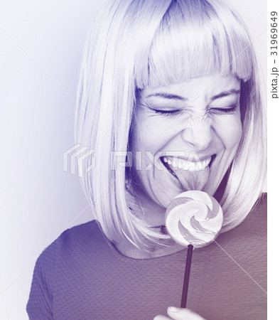 Woman smiling and eating lollipop candy Woman smiling and eating lollipop candy 31969649