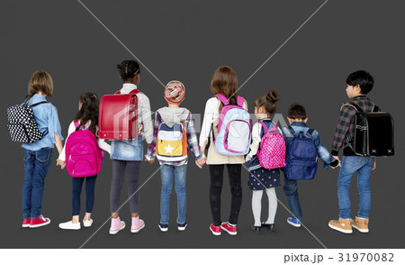 Rear view group of diverse kids standing in a row holdings hands Rear view group of diverse kids standing in a row holdings hands 31970082