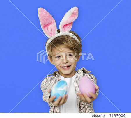 A boy with bunny hairband and easter eggs A boy with bunny hairband and easter eggs 31970094