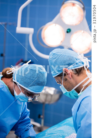 Surgeons performing operation in operation room Surgeons performing operation in operation room 31970504