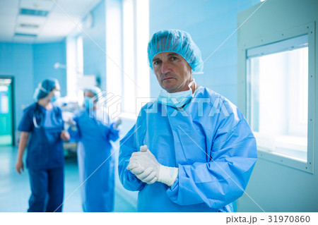 Portrait of surgeon standing in operation room Portrait of surgeon standing in operation room 31970860