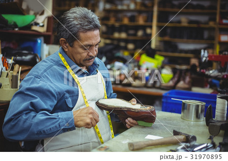 Shoemaker repairing a shoe 31970895